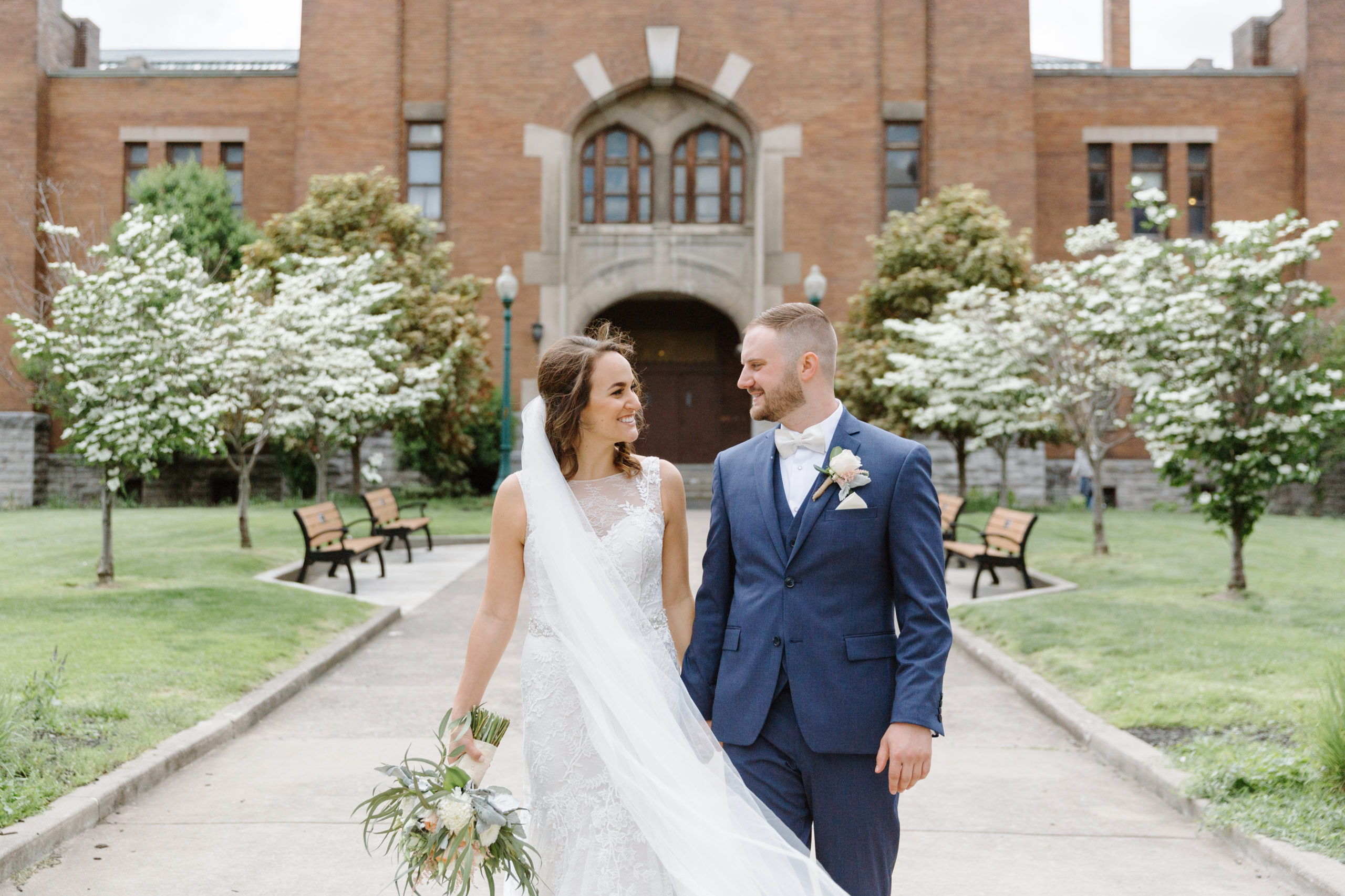 bride and groom look at each other and hold hands in downtown syracuse