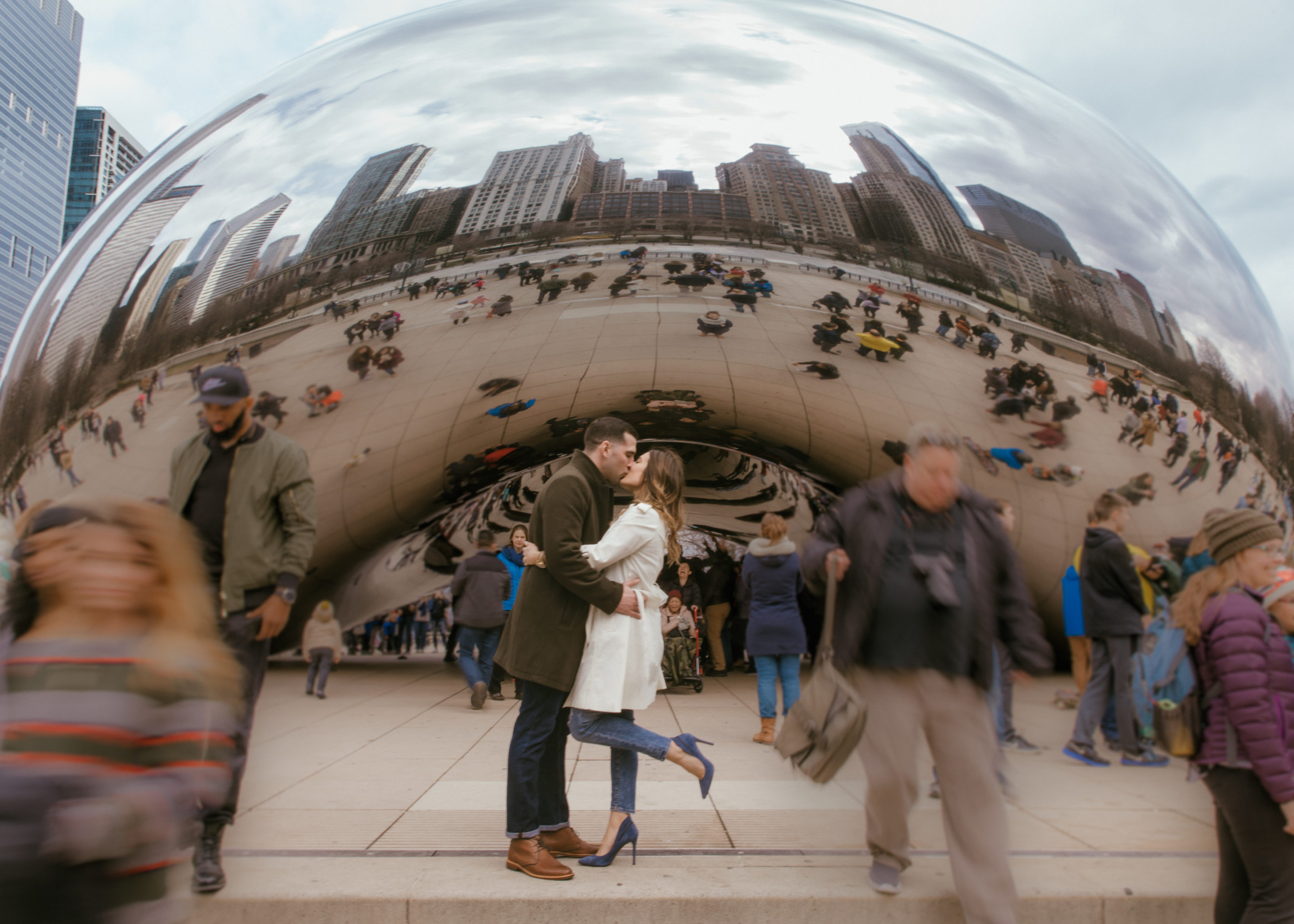 couple kisses in front of the Chicago bean