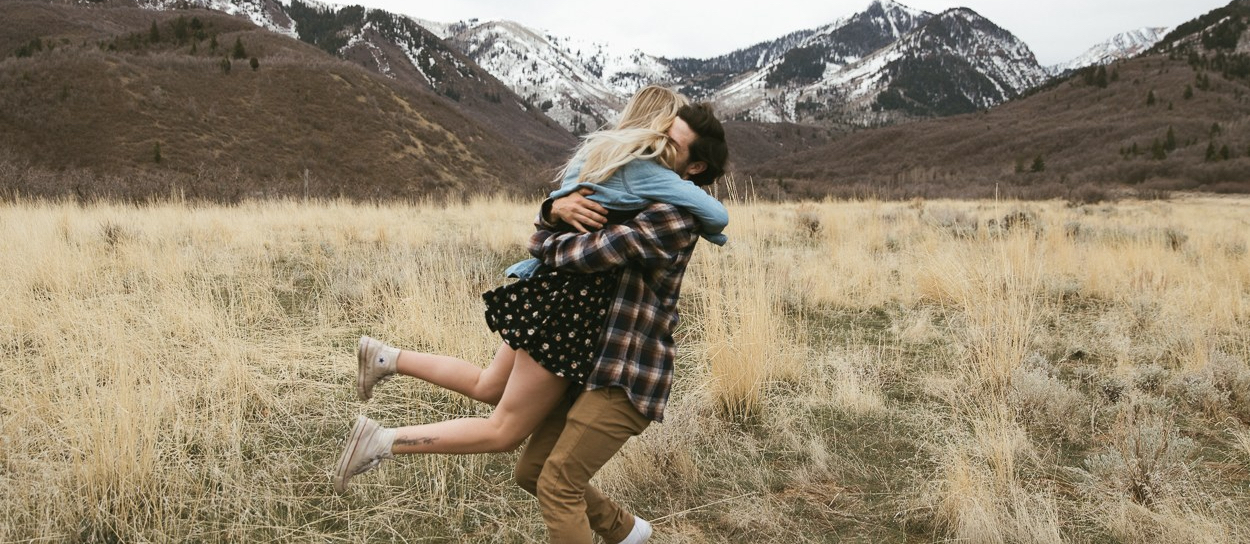 couple hugging in a field in the Utah mountains