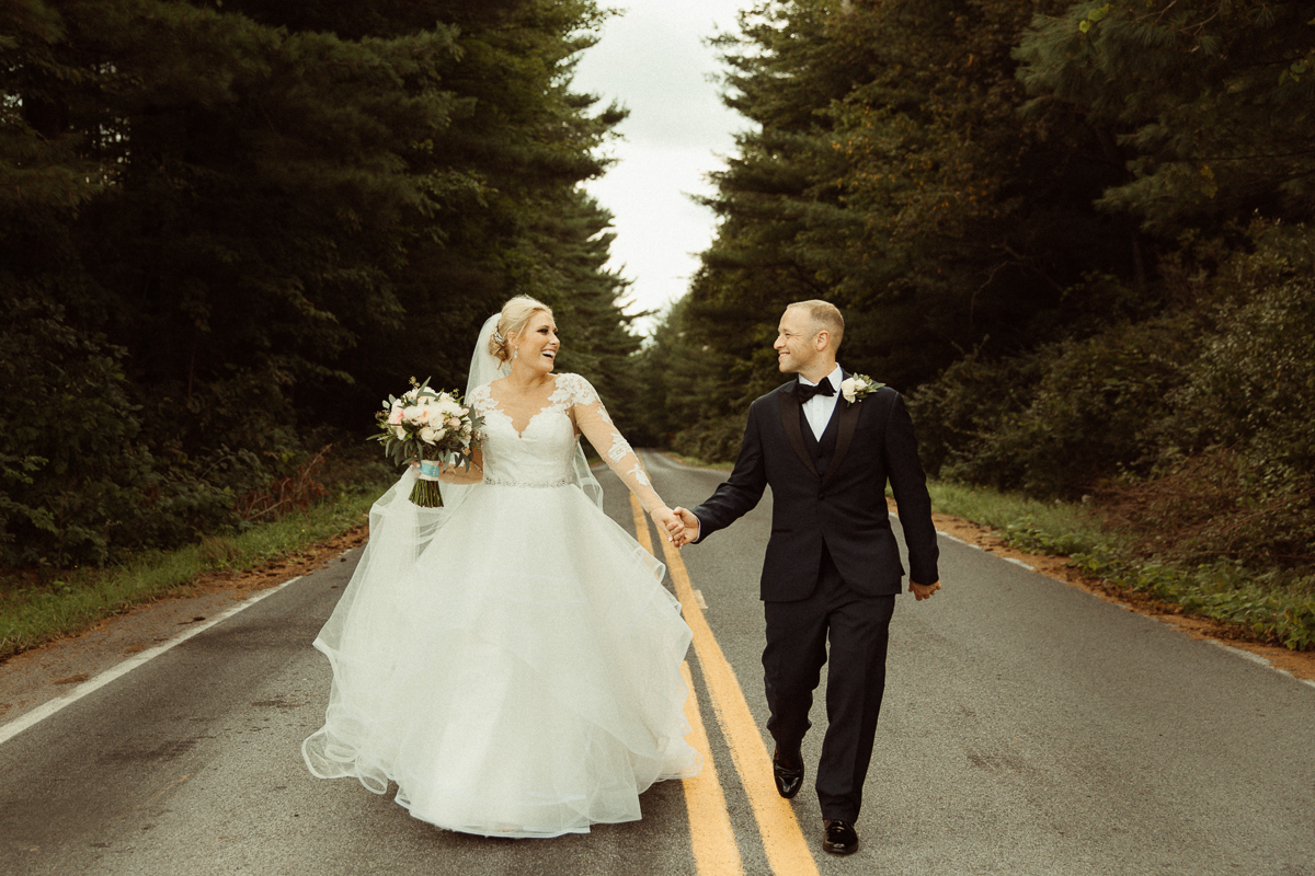 wedding couple holding hands and walking down road in Baldwinsville, NY