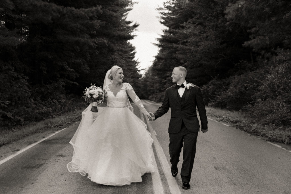 bride and groom running down the road holding hands