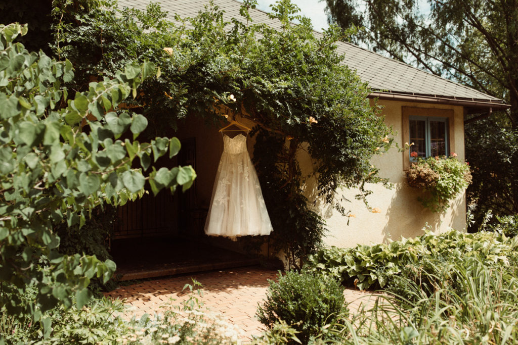 A wedding dress hangs in the doorway of a French inspired garden and chateau at Mirbeau Inn and Spa.