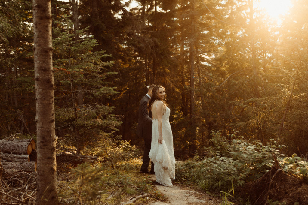 A couple walking through the forest on their elopement day in the Adirondacks.