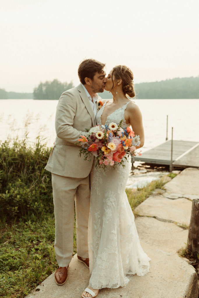 A couple standing on a dock at Lake Placid, celebrating their elopement in the Adirondacks.