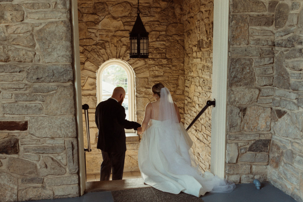 A couple walking down the stairs of the Onondaga Gold and Country Club, one of the best wedding venues in Syracuse.