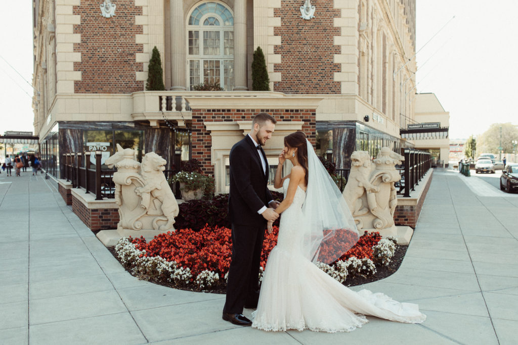 A couple standing in front of the Marriott Hotel, one of the best wedding venues in Syracuse. 