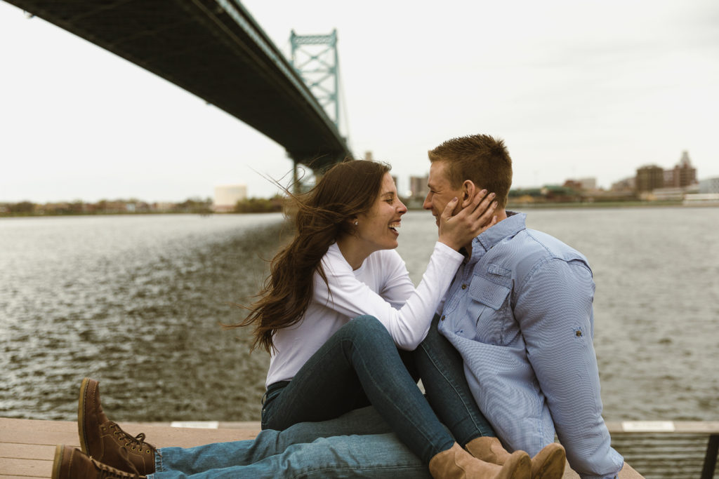 A couple goes to their favorite date night spot for their engagement session, under the bridge in their favorite city.