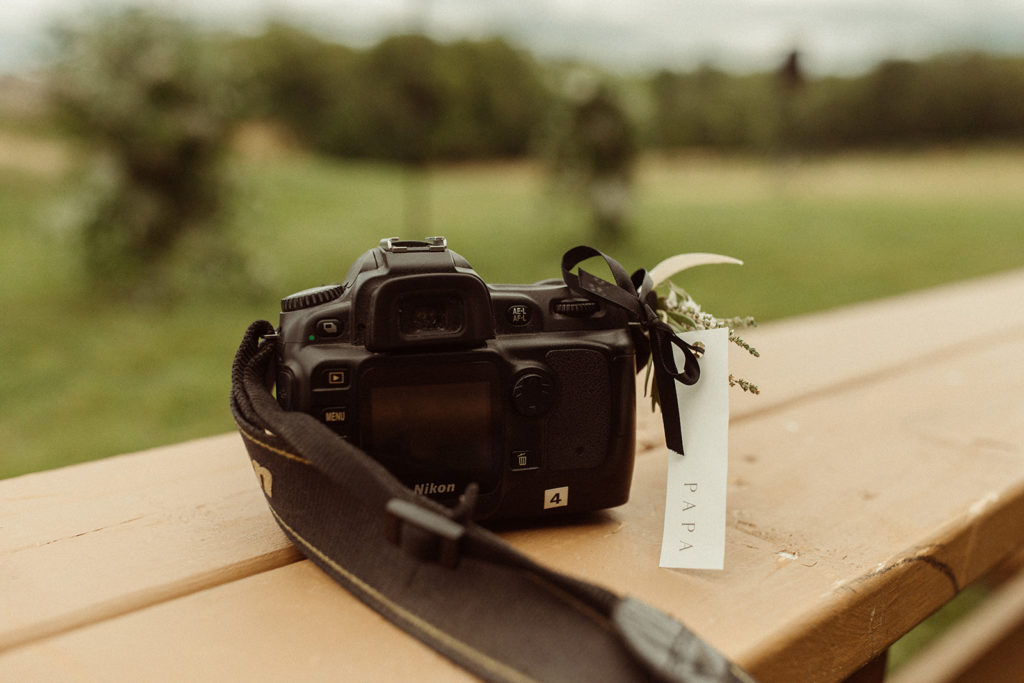 Camera sits on a bench to represent Grandfather who has passed, in a unique wedding ceremony 
