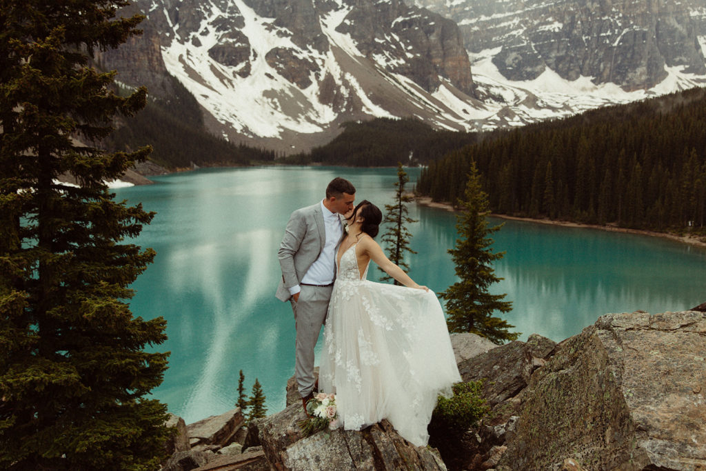 Couple gets married with lake and mountains in National Park. They chose their favorite place to make their wedding ceremony unique.