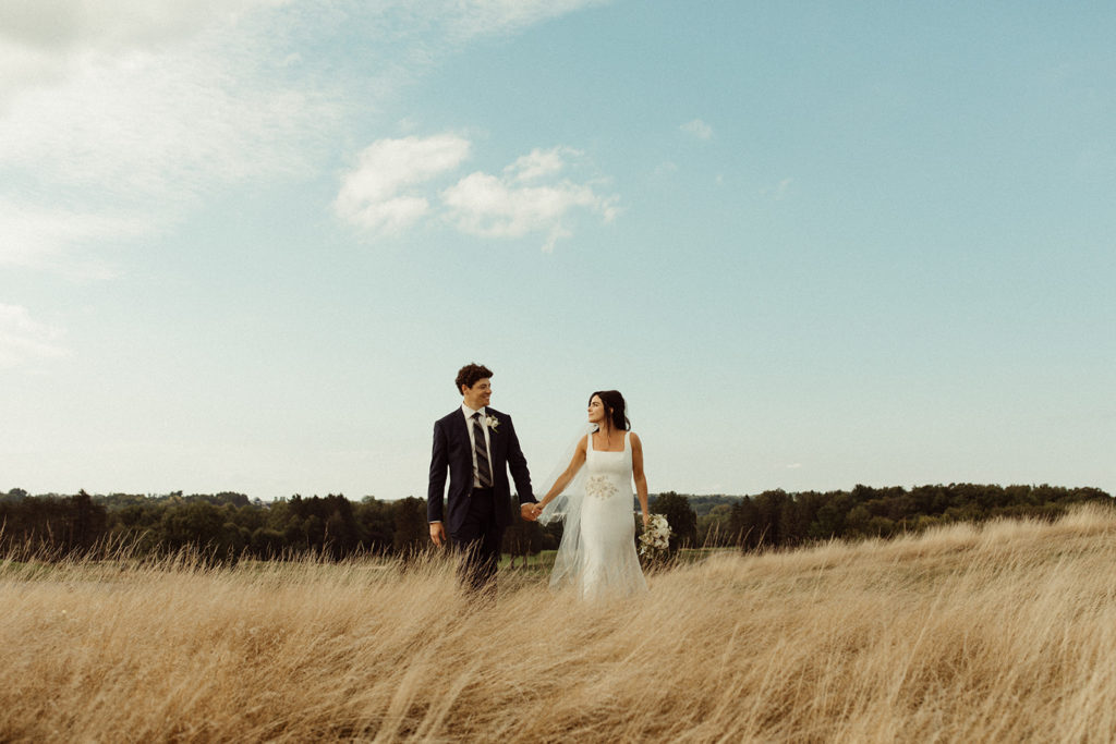 A couple stands in the tall glass at their Mohawk Valley wedding, a popular region in NY for weddings.