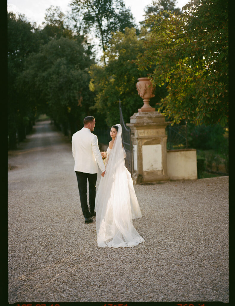 A film photograph of a bride walking away at Villa Corsini, a luxury wedding venue in Tuscany Italy.